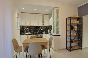 a kitchen with a wooden table and chairs at Mato Luxury Apartments 3 in Sarandë