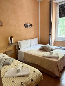 ein Schlafzimmer mit zwei Betten und einem Fenster in der Unterkunft Duca's Guest House in Turin