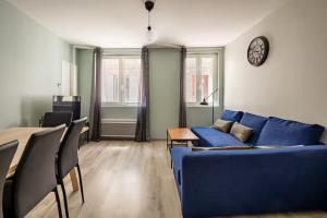 ein Wohnzimmer mit einem blauen Sofa und einem Tisch in der Unterkunft Maison rénové au cœur de Blaye in Blaye