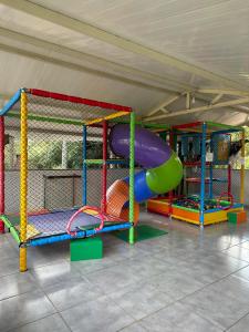 a play room with a slide and other play equipment at Pousada dos Azevedo in Cláudio