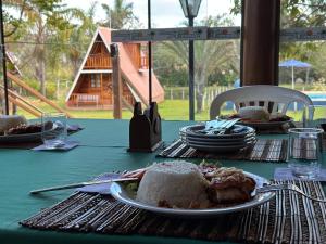 a green table with a plate of food on it at Pousada dos Azevedo in Cláudio