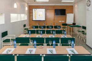 a conference room with tables and chairs with water bottles on them at Hotel Agora in Port de la Selva