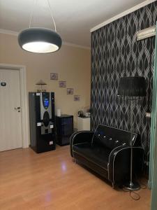 ein Wohnzimmer mit einem schwarzen Sofa und einem TV in der Unterkunft Duca's Guest House in Turin + 5 Fotos