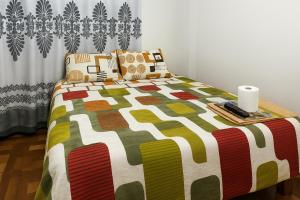 Carazhostal kactus的一间卧室配有一张带彩色床罩的床