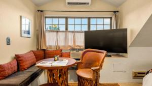 a living room with a couch and a table and a television at Tubac Country Inn in Tubac
