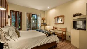 a bedroom with a large bed and a television at Tubac Country Inn in Tubac
