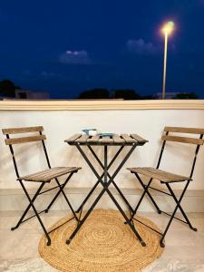 two chairs and a table on a balcony at night at Dimora Il Girasole in Torre San Giovanni Ugento +31 photos
