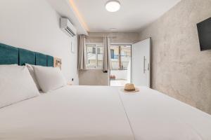 a bedroom with a large white bed with a hat on it at Hotel Sarikas in Polychrono