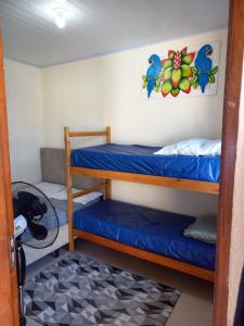 a bedroom with two bunk beds in a room at Casa na praia in Caraguatatuba