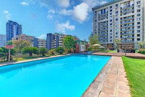 a large swimming pool in front of a building at Comfort Apartment SA in Johannesburg