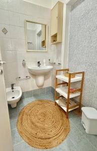 a bathroom with a sink and a toilet and a mirror at Dimora Il Girasole in Torre San Giovanni Ugento