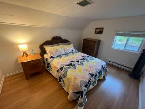 トウィリンゲートにあるScout's Houseのウッドフロアのベッドルーム1室(ベッド1台、ランプ付)