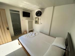 a small bedroom with a bed and a clock on the wall at Hotel Lina Maria in Tuluá