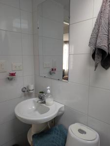 a bathroom with a sink and a toilet and a mirror at Alojamiento privado ubicado en la mejor zona de Manizales in Manizales
