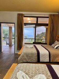 a bedroom with two beds and a large window at Hotel Mercy in San Juan La Laguna