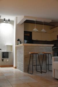 eine Küche mit einer Theke und 2 Hockern in einem Zimmer in der Unterkunft Terrazza Sole e Stelle in Matera