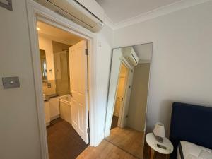 a room with a hallway with a mirror and a couch at The Orderly By Estatesmen in London