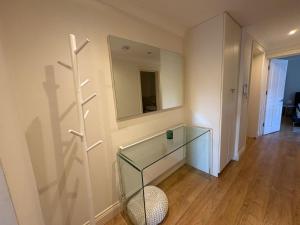 a room with a glass table and a mirror at The Orderly By Estatesmen in London