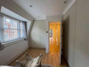 an empty room with a window and a chair at The Orderly By Estatesmen in London