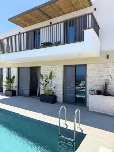 a house with a swimming pool and a balcony at Sunrise Village Aptera Private Pool Villa in Beritianá