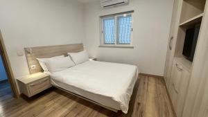 a small bedroom with a bed and a window at Casa Luca in Carvoeiro