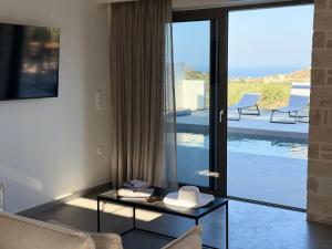 a living room with a glass door leading to a patio at Sunrise Village Aptera Private Pool Villa in Beritianá