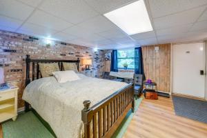 Un dormitorio con una cama y una pared de ladrillo. en 7 Mi to Beckley Townhome Near Hiking and Fishing, 