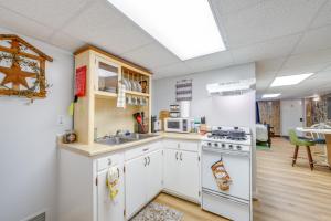 Una cocina con gabinetes blancos, un fregadero y una estufa. en 7 Mi to Beckley Townhome Near Hiking and Fishing, 