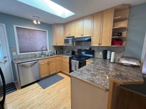a kitchen with wooden cabinets and granite counter tops at Heavenly Cozy Place Inc in Airdrie