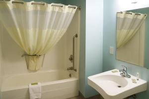 a bathroom with a sink and a tub and a shower at Raceway Inn in Darlington