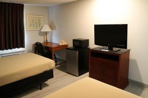 a hotel room with a bed and a flat screen tv at Raceway Inn in Darlington