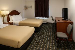 a hotel room with two beds and a television at Raceway Inn in Darlington