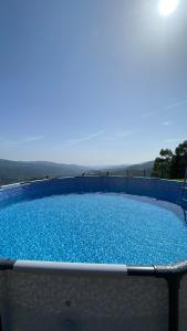 una grande piscina con acqua blu su un patio di Villa Garcia a Terras de Bouro