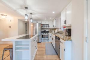 eine Küche mit weißen Schränken und Geräten aus Edelstahl in der Unterkunft Modern 3-Bedroom Escape in Northwest Reno in Reno