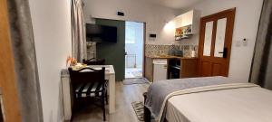 a bedroom with a bed and a desk and a kitchen at Studio Apartment in Collingwood Park