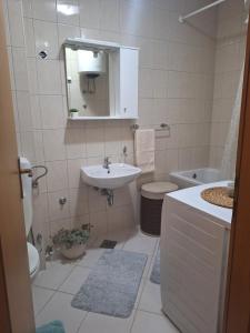 a bathroom with a sink and a toilet and a mirror at Seaview apartman Vice in Trogir +16 photos