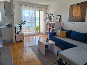 a living room with a blue couch and a table at Seaview apartman Vice in Trogir