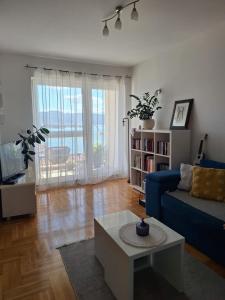 a living room with a blue couch and a coffee table at Seaview apartman Vice in Trogir