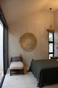 a bedroom with a bed and a chair and a mirror at CASA TAMA in La Ermita, Mérida Center with pool in Azcorra