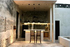 two chairs sitting at a bar in a kitchen at CASA TAMA in La Ermita, Mérida Center with pool in Azcorra