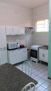 eine kleine Küche mit weißen Schränken und einer Mikrowelle in der Unterkunft Apartamento - centro in Bom Jesus da Lapa