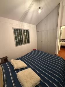 a bedroom with a bed with blue and white stripes at Departamento en Salta Capital in Salta
