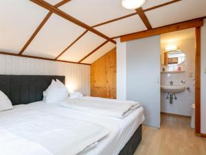 ein Schlafzimmer mit einem großen Bett und einem Waschbecken in der Unterkunft Rettenstein und Gaisbergblick in Kirchberg in Tirol
