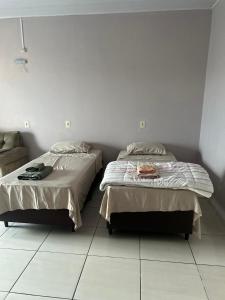 two beds sitting next to each other in a bedroom at Kitnet RS- Espaço Confortável in Canoinhas