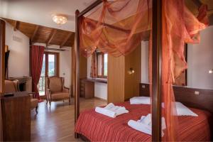 a bedroom with a four poster bed with red sheets at Athina Luxury Villas in Xamoudhokhórion +42 photos