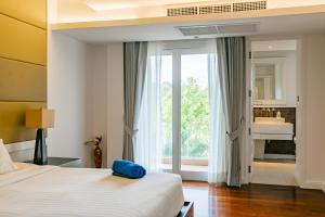 a hotel room with a bed and a window at 3BR Casa Azul - Beachfront Home in Laguna & Layan Chom Tawan and Maan Tawan Residences in Phuket Town +54 photos