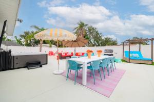 a table with chairs and an umbrella on a patio at Cozy 3BD ‘Sweet Memories’ | Pool, Games & Hot Tub in Cedar Hammock