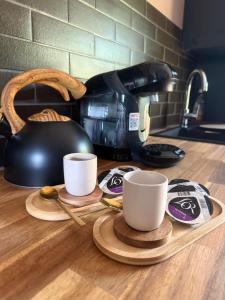 a counter with two coffee cups and a tea pot at Loveroom La suite des murmures in Scionzier