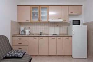 a small kitchen with a refrigerator and a microwave at Apartments with WiFi Lopar, Rab - 14804 in Lopar