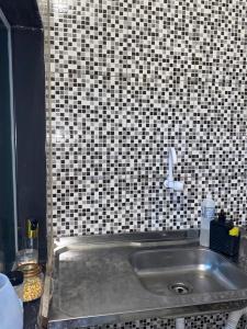 a sink in a bathroom with black and white tiles at Apartamento 02 completo Natal ZN próx norte shopping e praias in Natal +25 photos